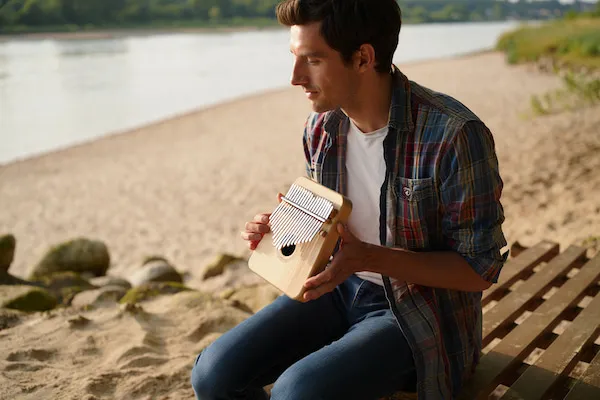 Image d'un homme en train de jouer du Kalimba sur la place