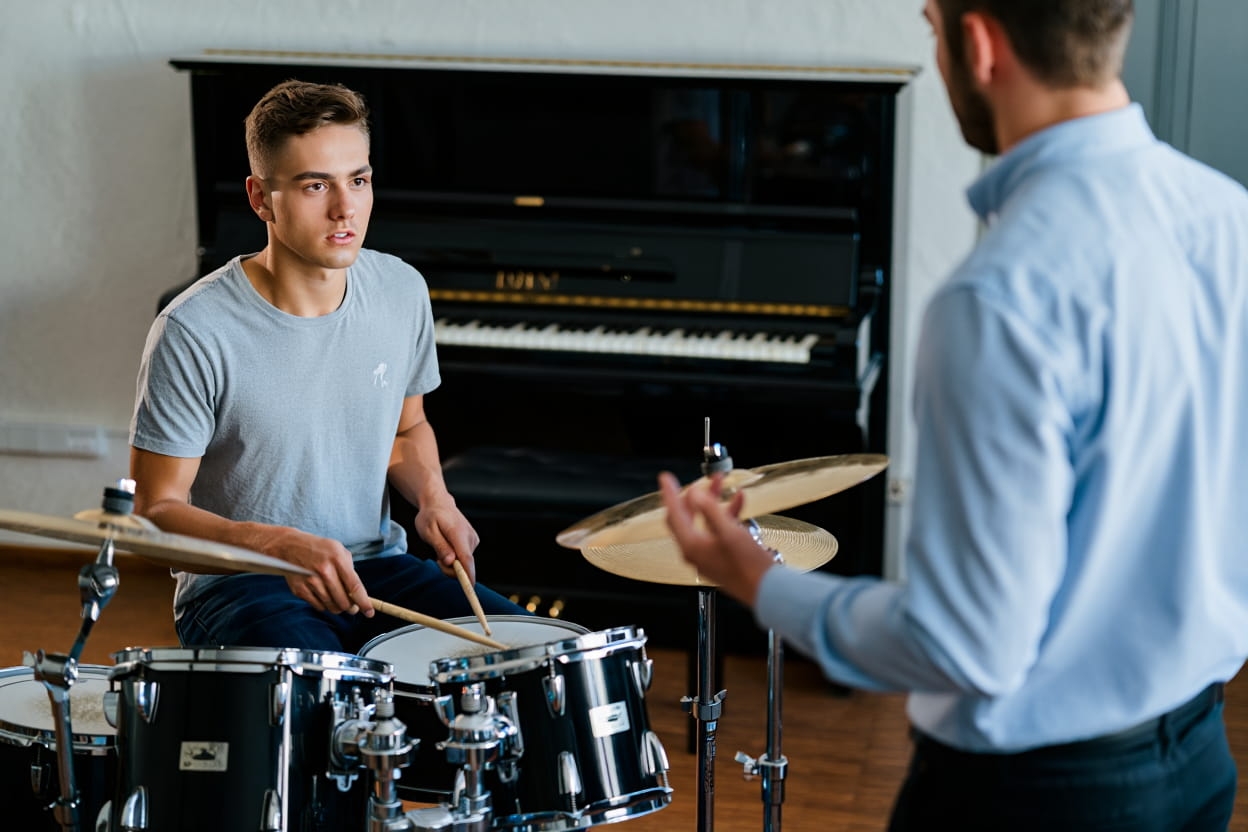 photo d’un élève dans un cours de batterie avec son professeur